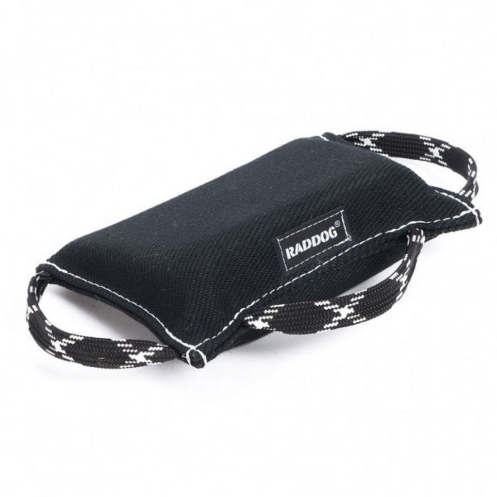 A black RADDOG bite pad with black handles, designed for puppy training.
